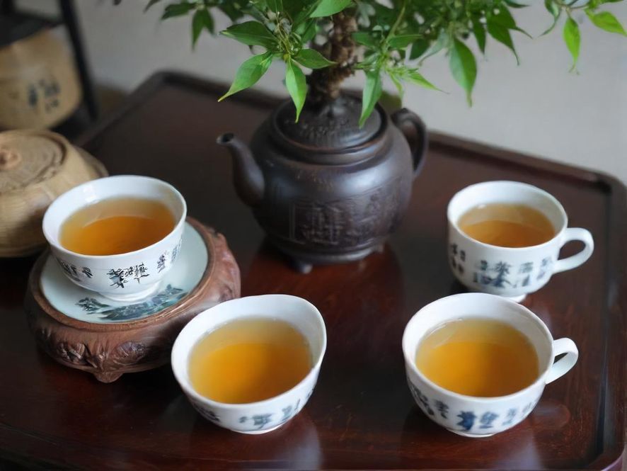 一位女士在现代风格的温州茶室中,侧面特写,姿态优雅地品尝着香茗